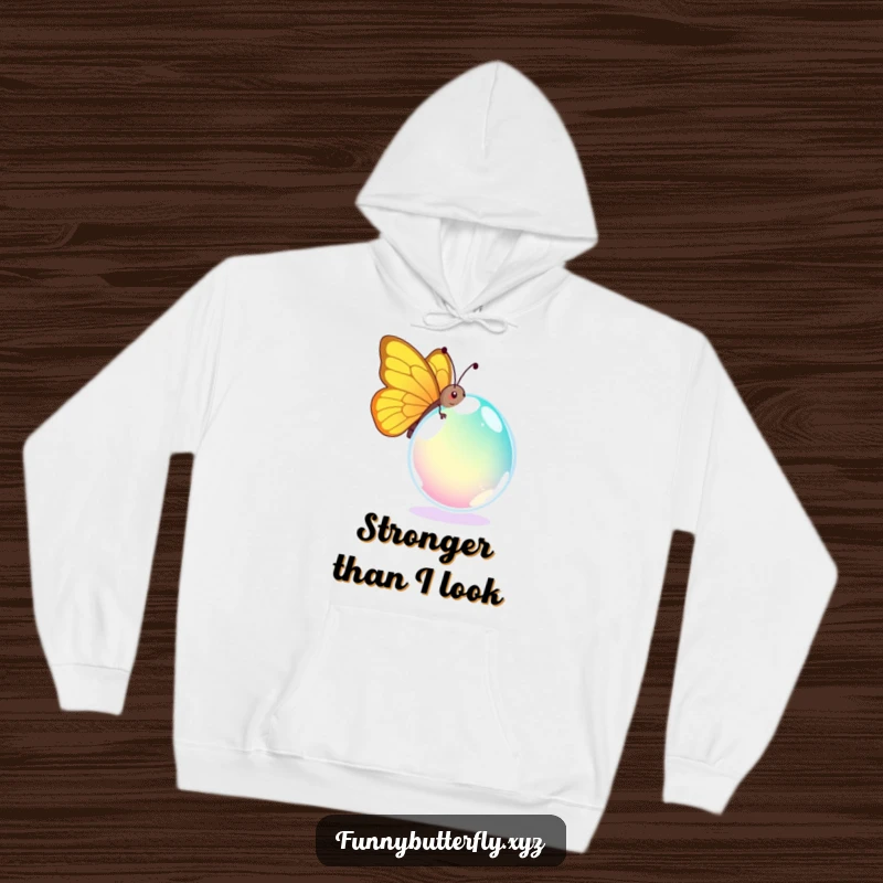 Funny hoodie capturing a comical butterfly's amusing effort to move a huge, colorful dewdrop, a humorous scene of tiny strength.